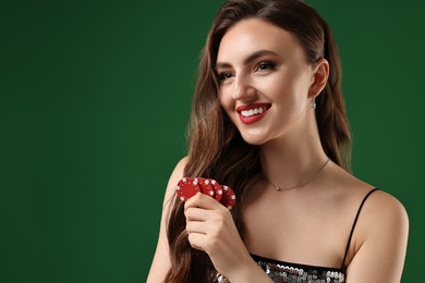 Photo of Smiling woman with poker chips on green background. Space for text