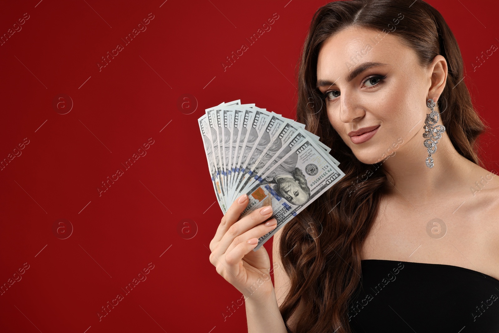 Photo of Charming woman with dollar banknotes on red background. Space for text