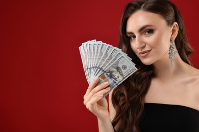Photo of Charming woman with dollar banknotes on red background. Space for text