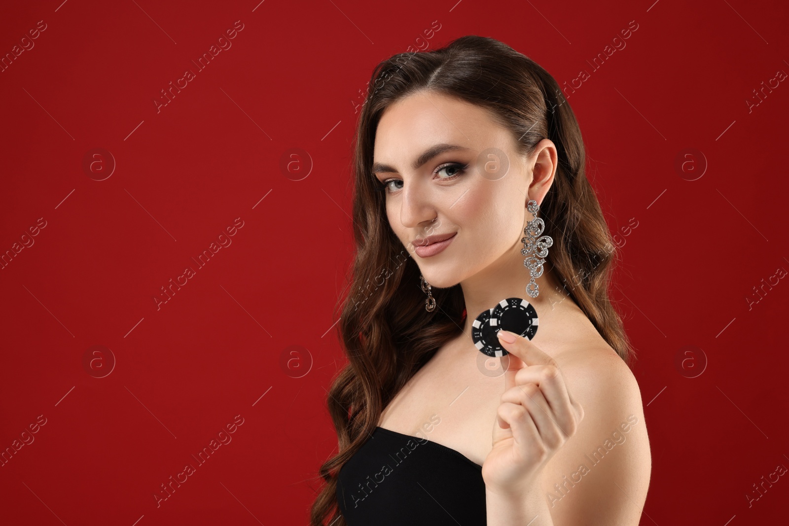 Photo of Charming woman with poker chips on red background. Space for text