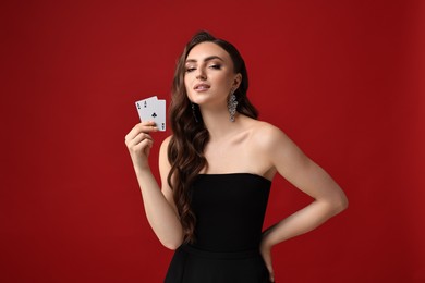 Photo of Poker game. Charming woman with playing cards on red background