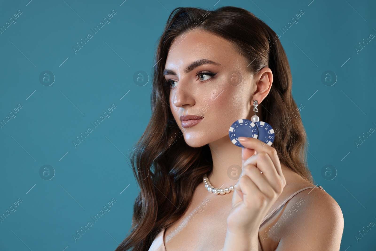 Photo of Charming woman with poker chips on light blue background. Space for text