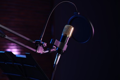 Stand with microphone and pop filter in record studio