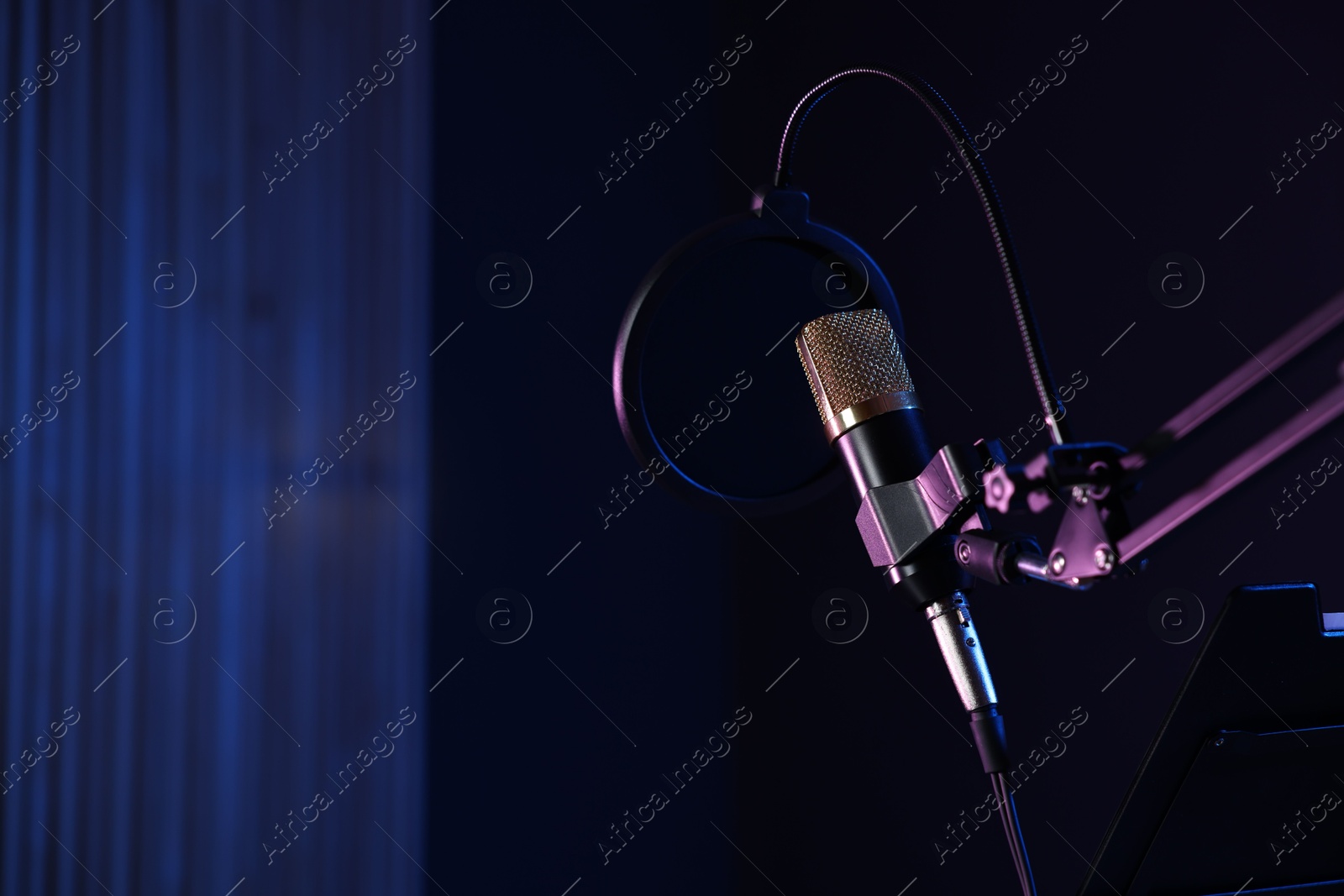 Photo of Stand with microphone and pop filter in record studio, space for text