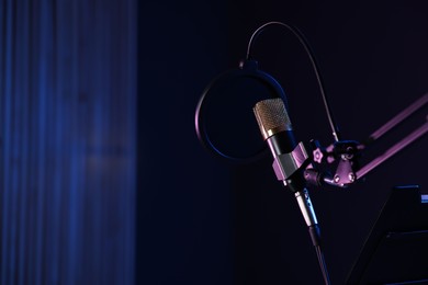 Photo of Stand with microphone and pop filter in record studio, space for text