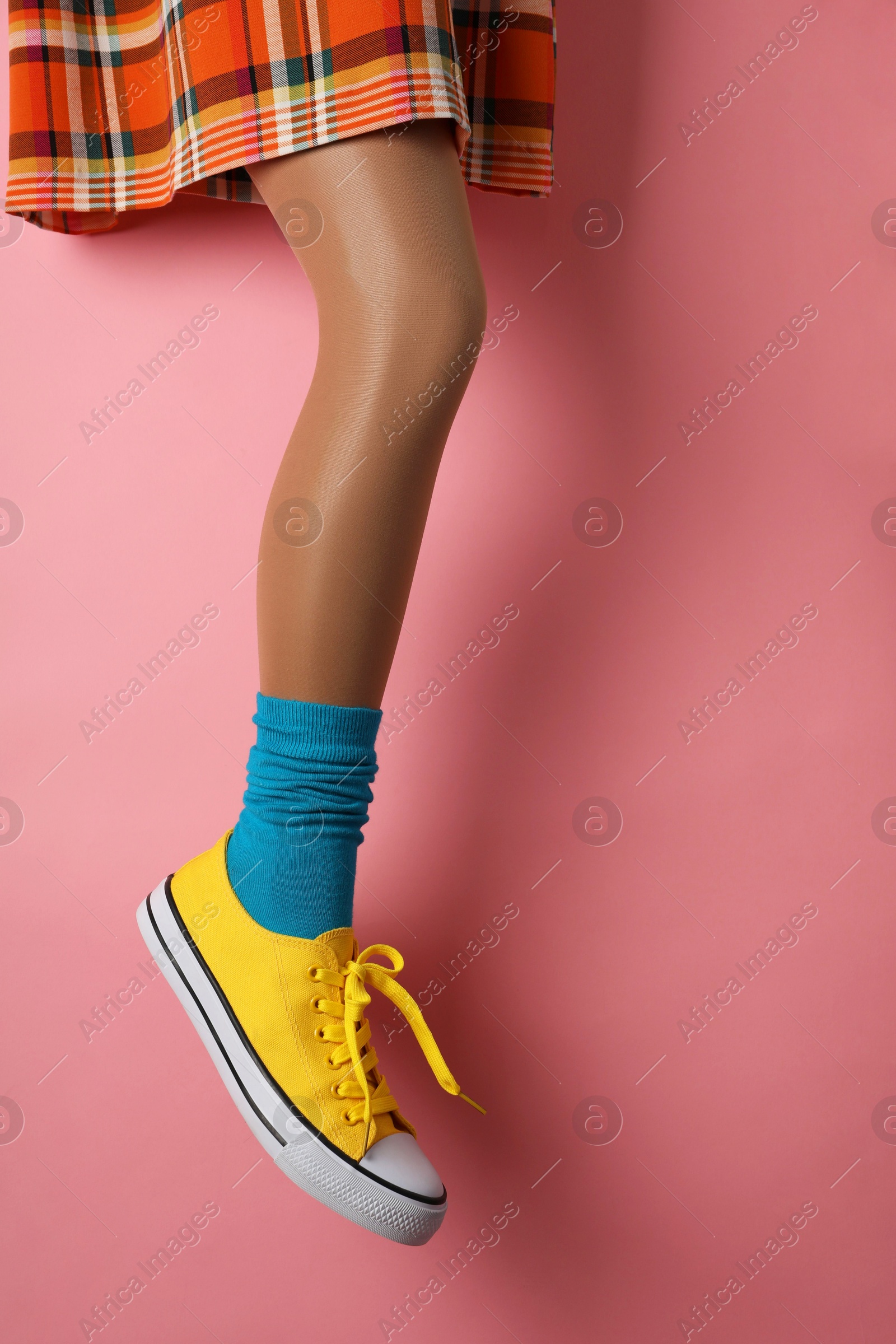 Photo of Woman wearing shoes on pink background, closeup