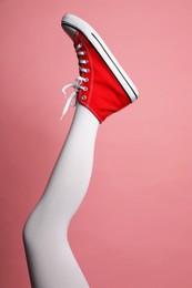 Photo of Woman wearing shoes on pink background, closeup