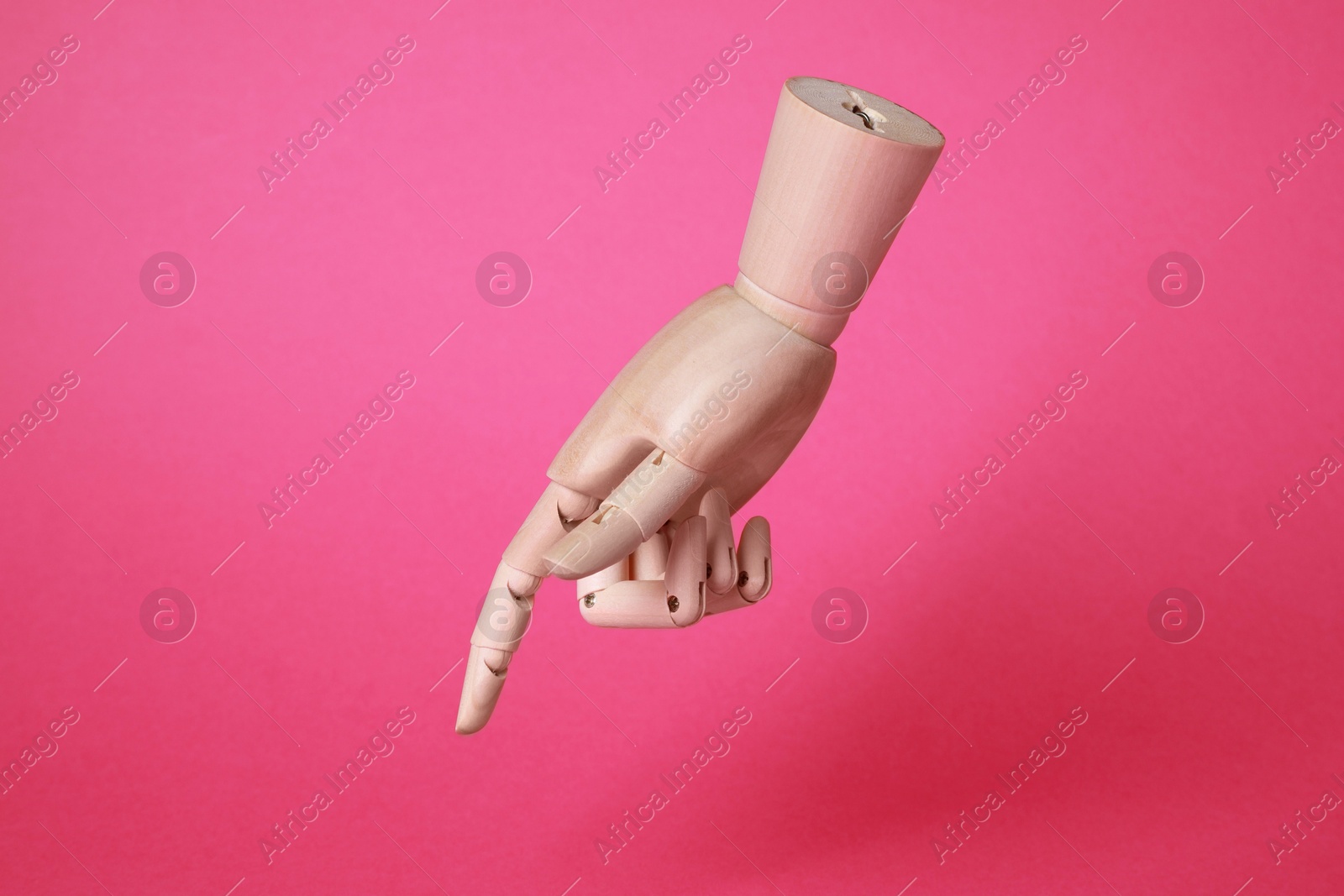 Photo of Wooden hand model on pink background. Mannequin part