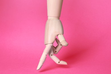 Wooden hand model on pink background. Mannequin part