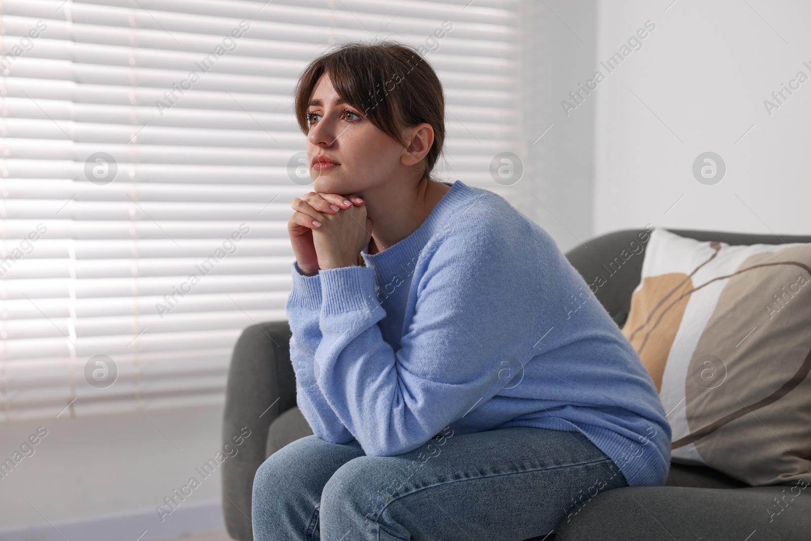 Photo of Loneliness concept. Sad woman sitting on sofa at home