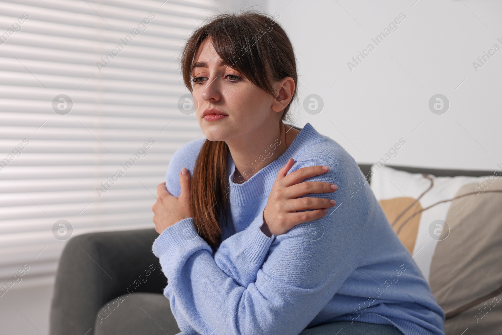 Photo of Loneliness concept. Sad woman sitting on sofa at home