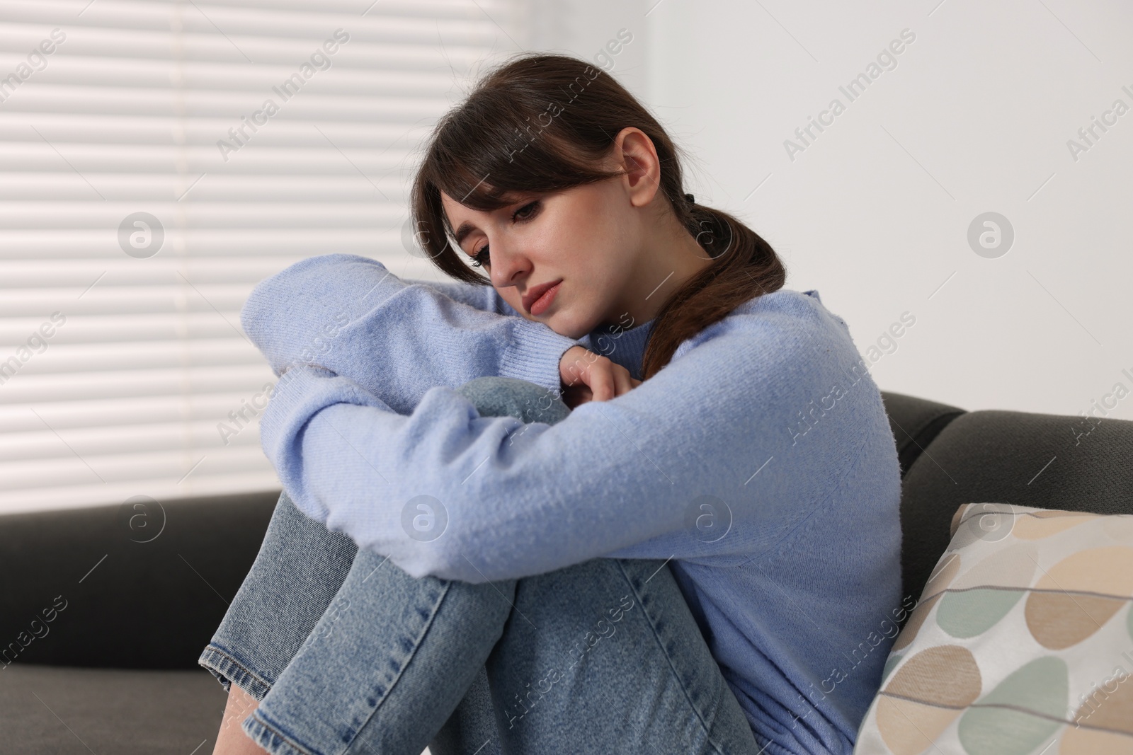 Photo of Loneliness concept. Sad woman sitting on sofa at home