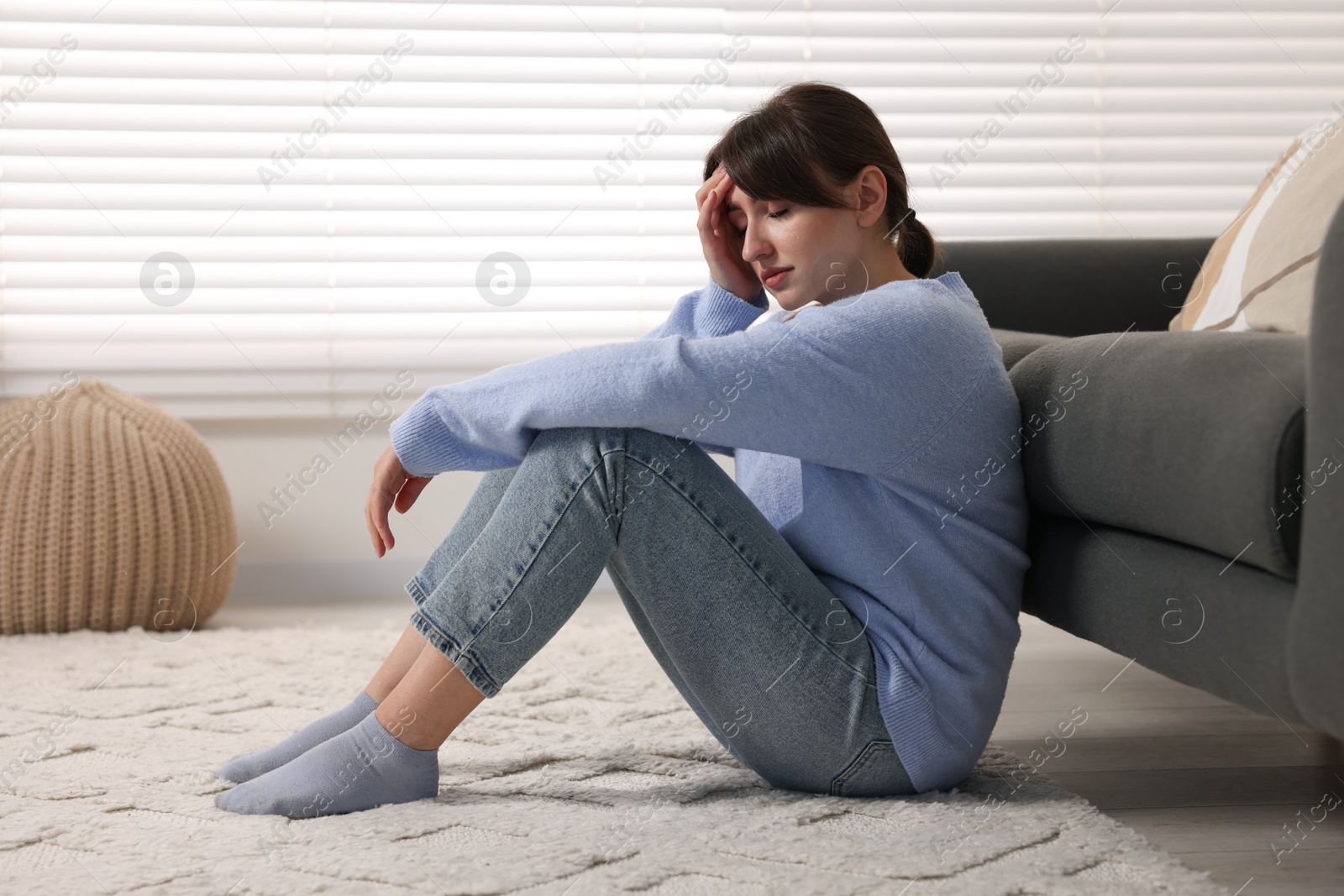 Photo of Loneliness concept. Sad woman sitting on floor at home
