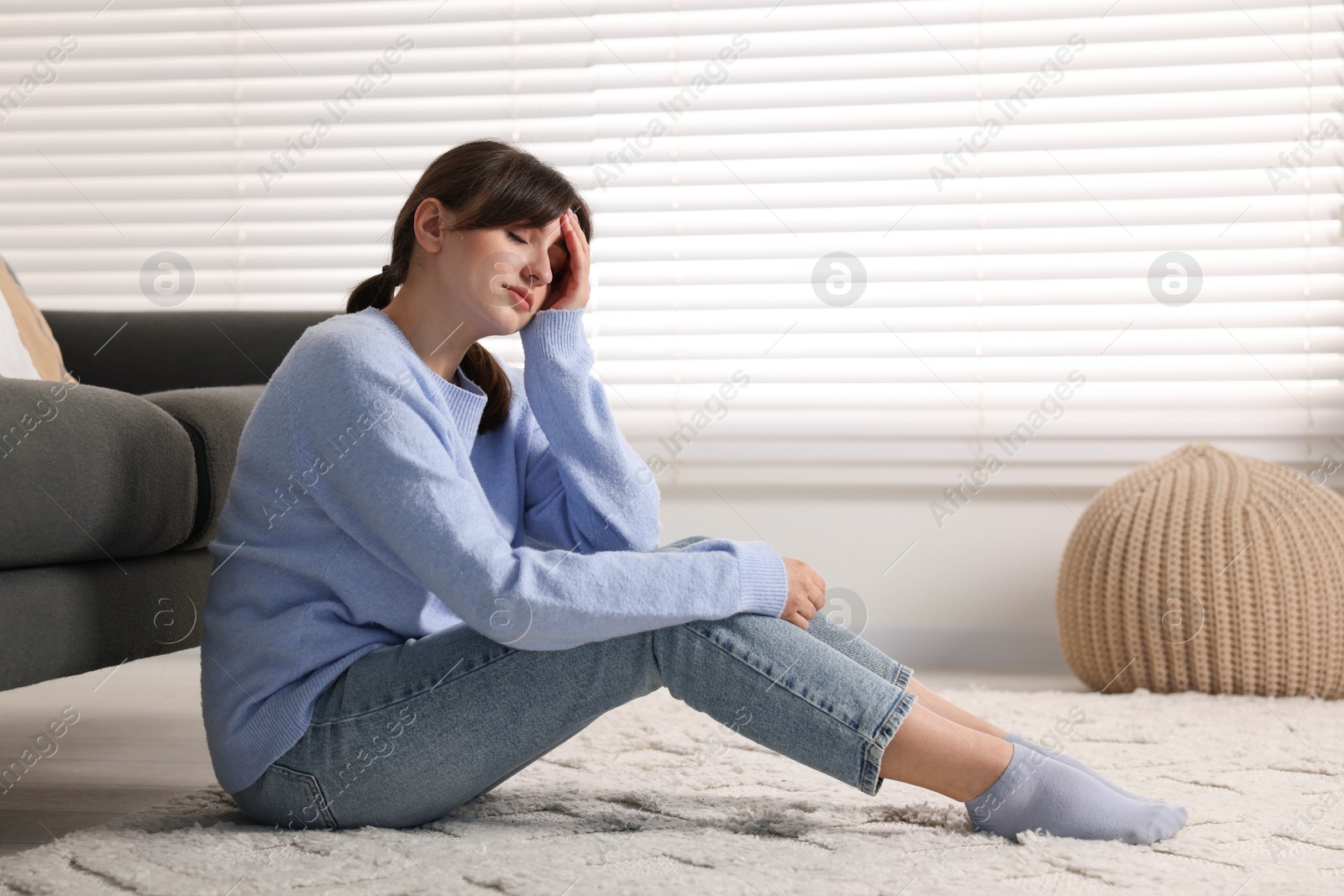 Photo of Loneliness concept. Sad woman sitting on floor at home