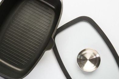 Photo of Black pot and glass lid on white background, top view