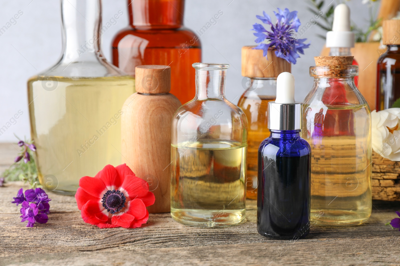 Photo of Aromatherapy. Different essential oils and flowers on wooden table