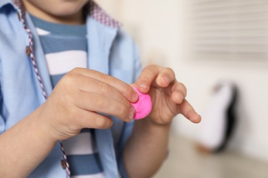 Photo of Little boy sculpting with play dough indoors, closeup