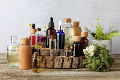 Photo of Aromatherapy. Different essential oils and flowers on wooden table