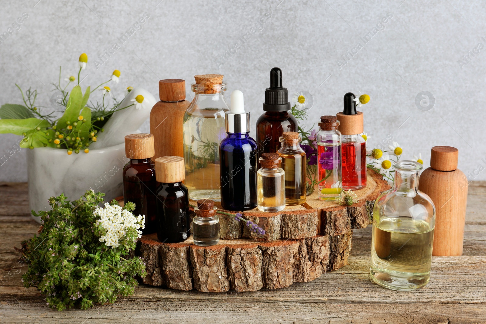 Photo of Aromatherapy. Different essential oils and flowers on wooden table