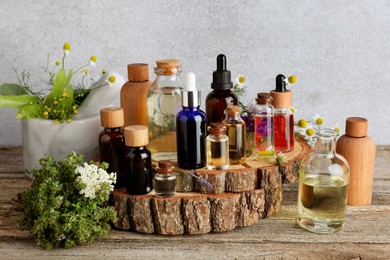 Photo of Aromatherapy. Different essential oils and flowers on wooden table