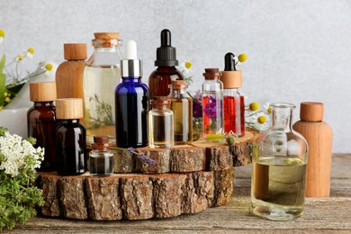 Photo of Aromatherapy. Different essential oils and flowers on wooden table