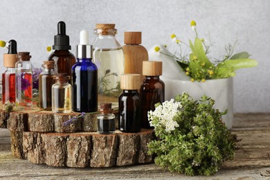 Photo of Aromatherapy. Different essential oils and flowers on wooden table