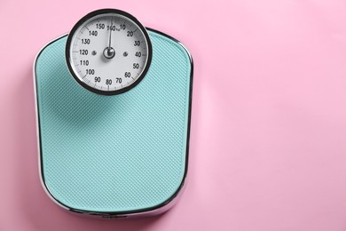 Photo of One bathroom scale on pink background, top view. Space for text