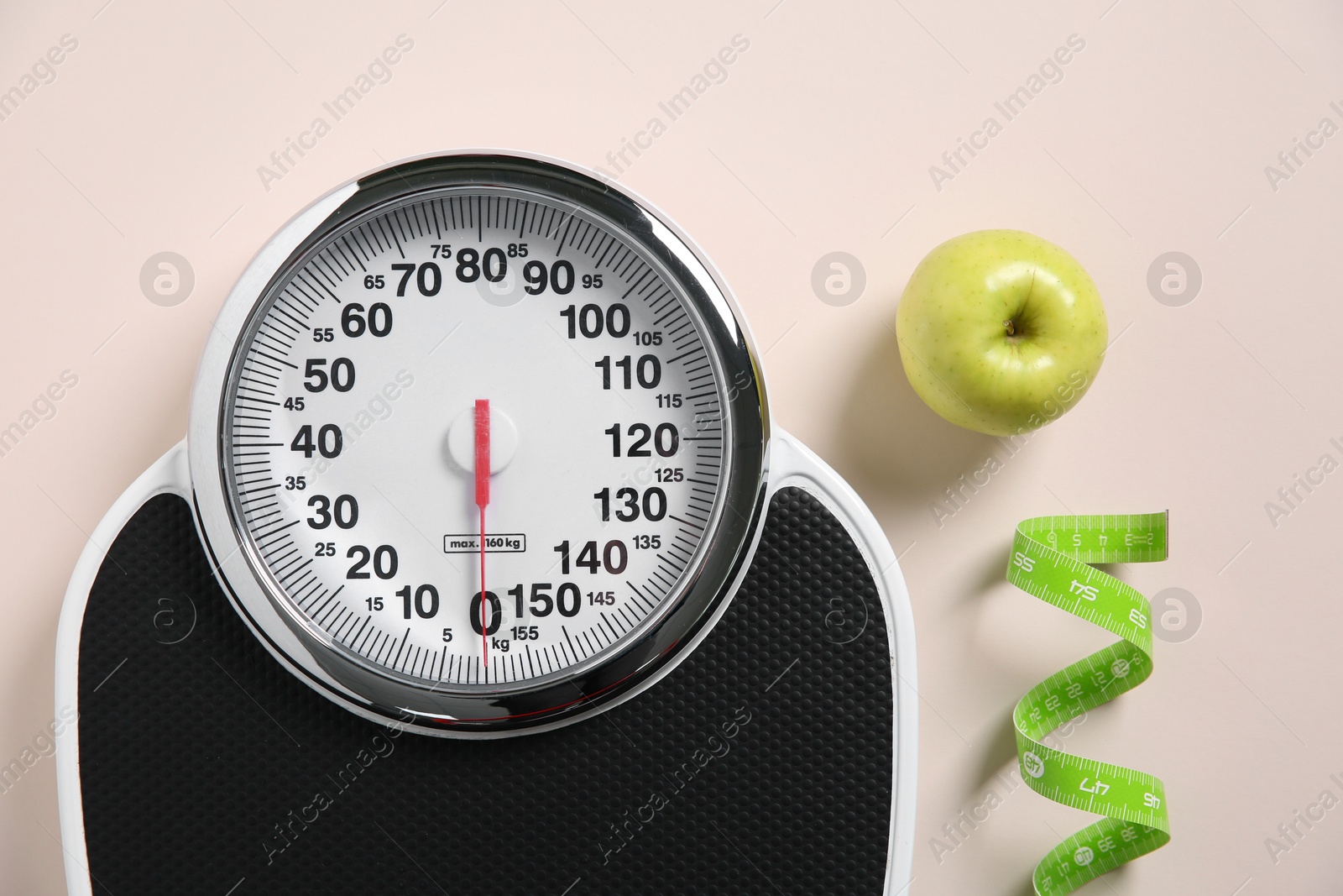 Photo of Scale, measuring tape and fresh apple on beige background, flat lay