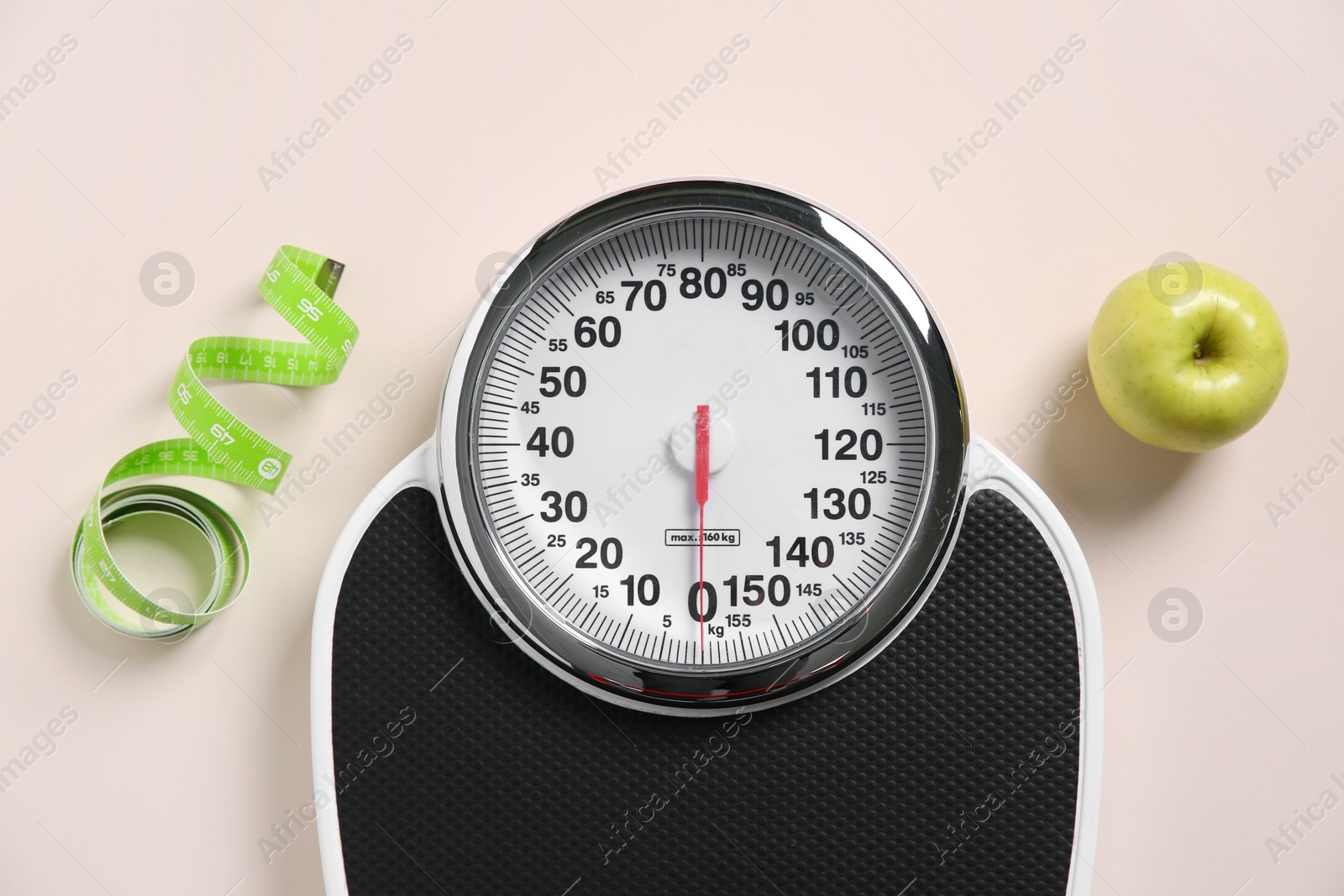 Photo of Scale, measuring tape and fresh apple on beige background, flat lay