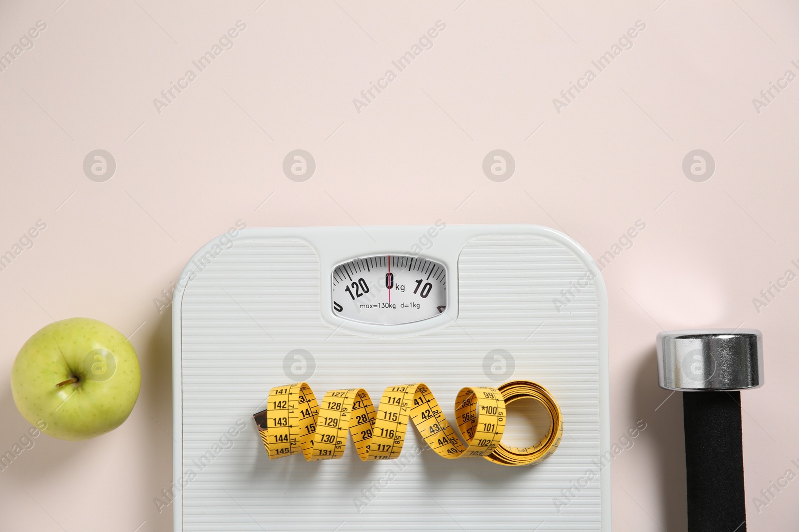 Photo of Scale, measuring tape, dumbbells and apple on beige background, flat lay. Space for text