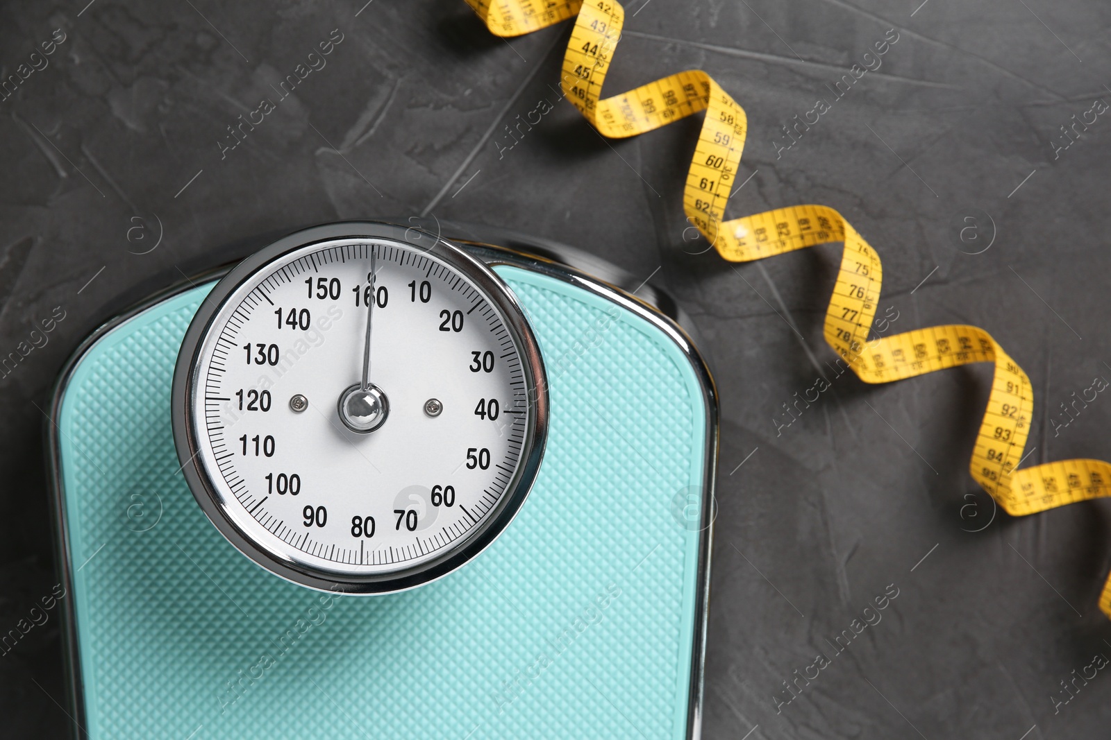 Photo of Scale and measuring tape on grey textured background, flat lay