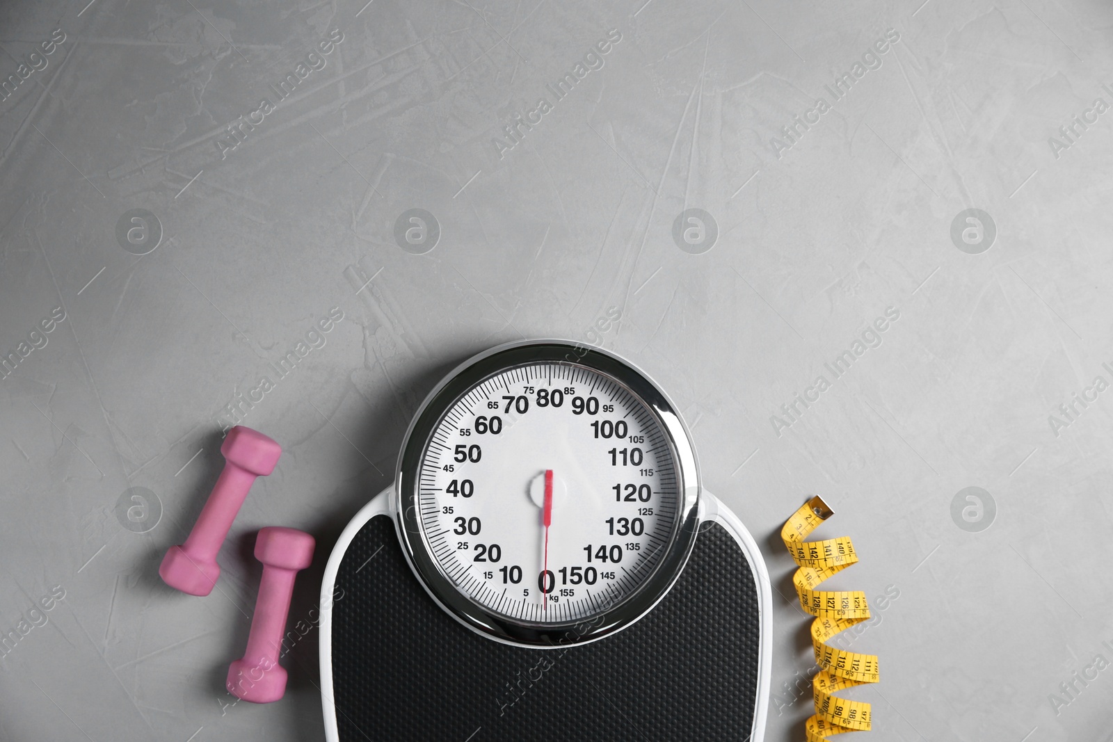 Photo of Bathroom scale, measuring tape and dumbbells on grey textured background, flat lay. Space for text