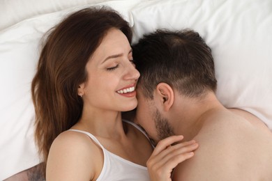 Lovely couple enjoying time together in bed at morning, top view