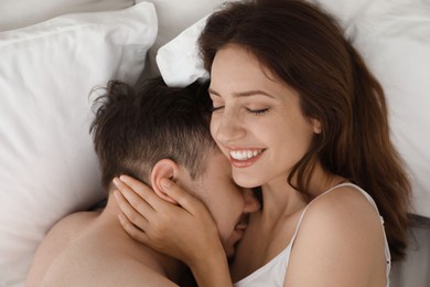 Photo of Lovely couple enjoying time together in bed at morning, top view