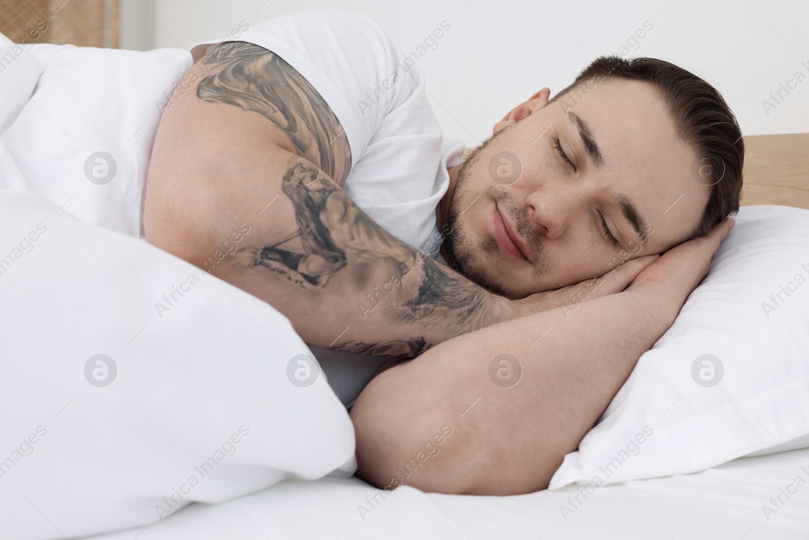 Photo of Bedtime. Handsome man sleeping in bed indoors