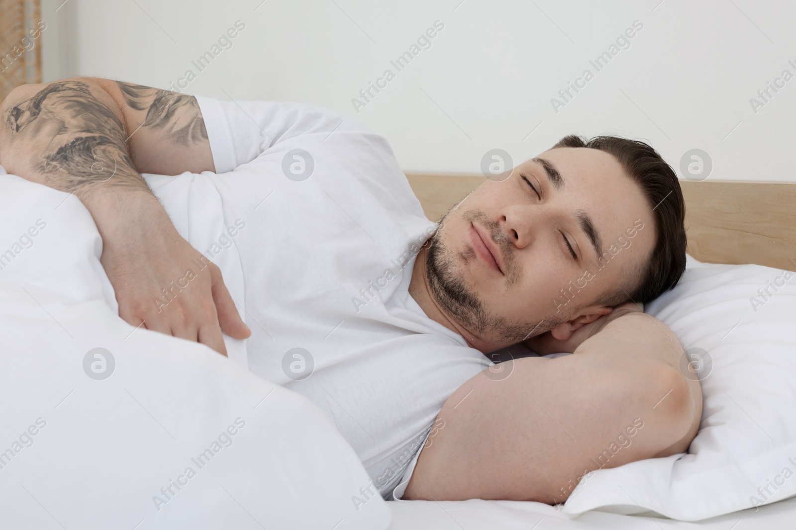 Photo of Bedtime. Handsome man sleeping in bed indoors