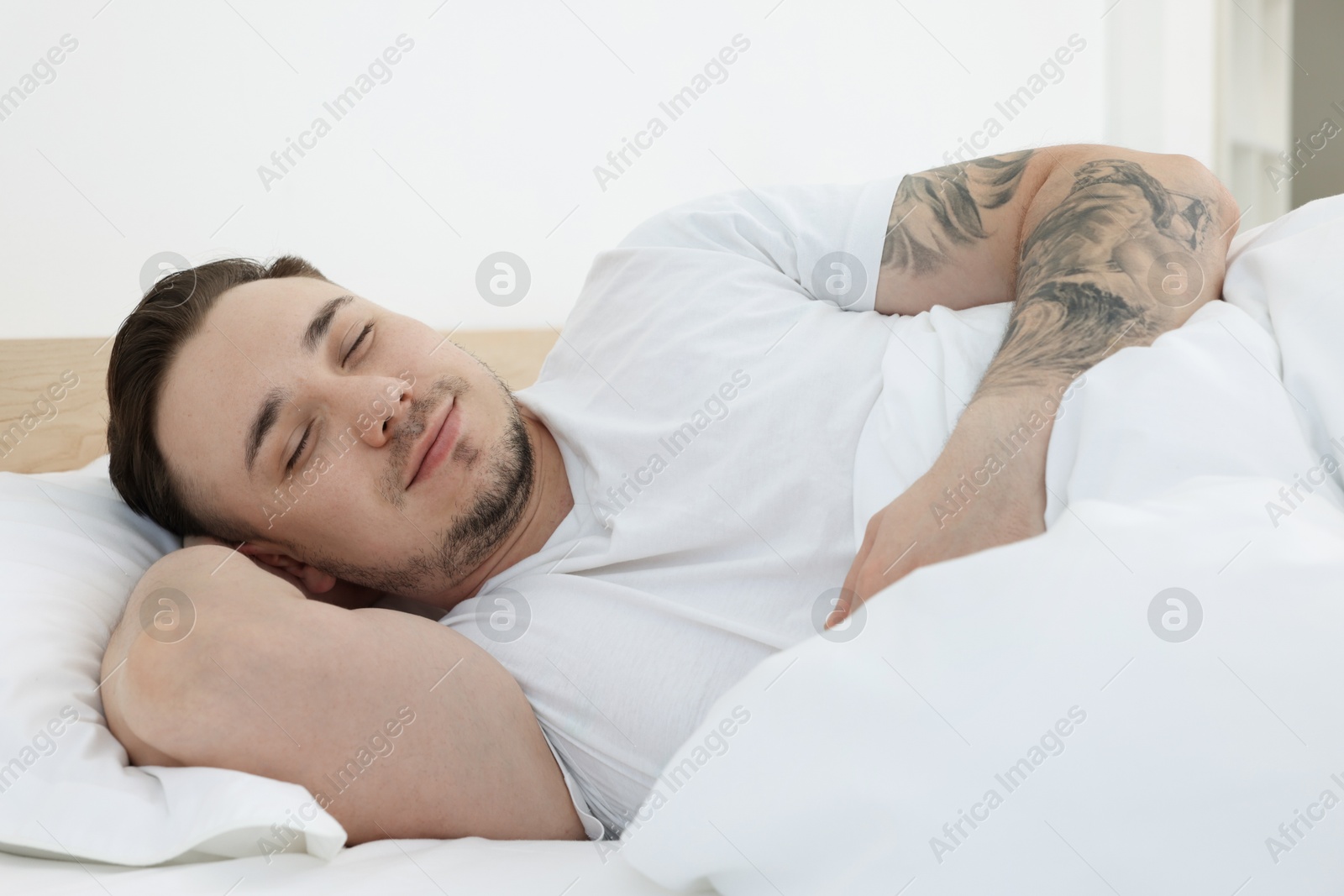 Photo of Bedtime. Handsome man sleeping in bed indoors