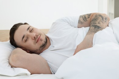 Photo of Bedtime. Handsome man sleeping in bed indoors