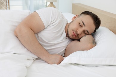 Photo of Bedtime. Handsome man sleeping in bed indoors