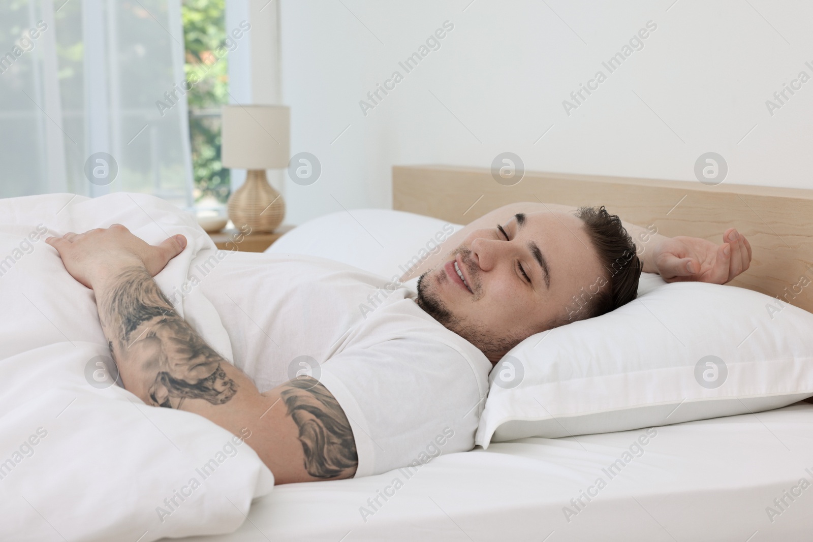 Photo of Bedtime. Handsome man sleeping in bed indoors