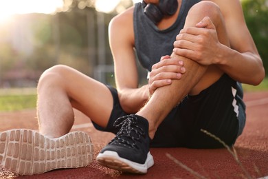 Sportsman with leg injury at stadium, closeup