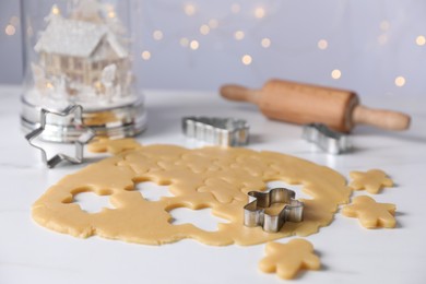 Photo of Making cookies. Raw dough and cutters on white table