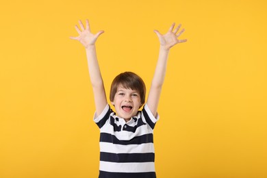 Photo of Portrait of cute little boy on orange background