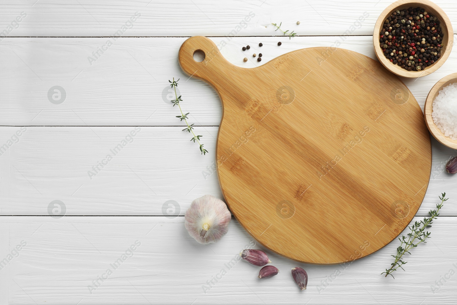 Photo of Cutting board and different spices on white wooden table, flat lay. Space for text