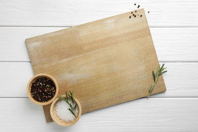 Photo of Cutting board and different spices on white wooden table, flat lay