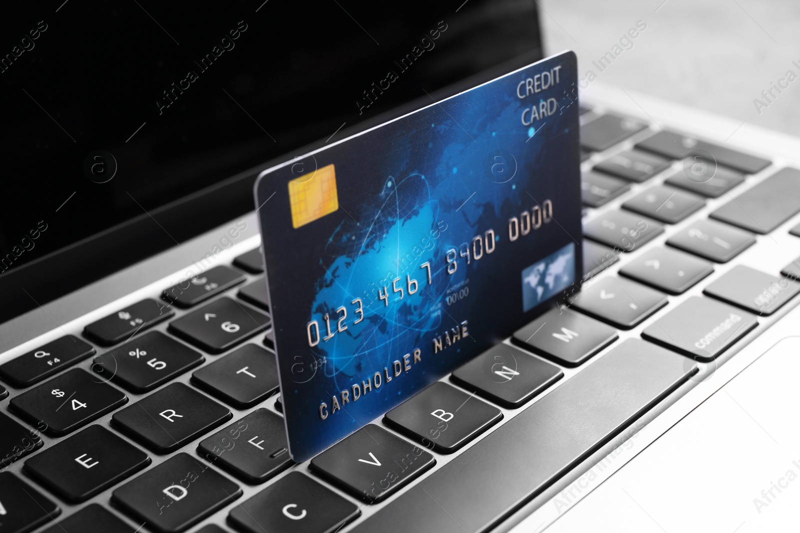 Photo of Laptop with credit card on table, closeup