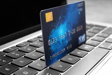 Photo of Laptop with credit card on table, closeup