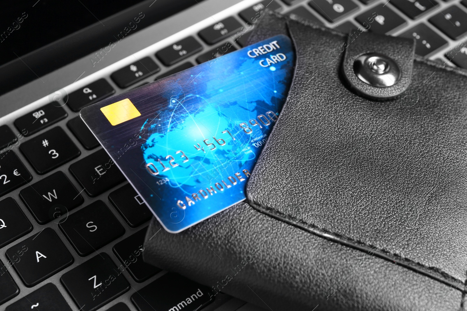 Photo of Credit card in leather wallet on laptop