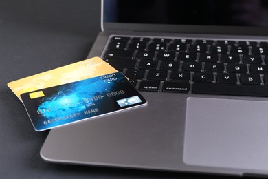 Laptop with credit cards on grey table, closeup