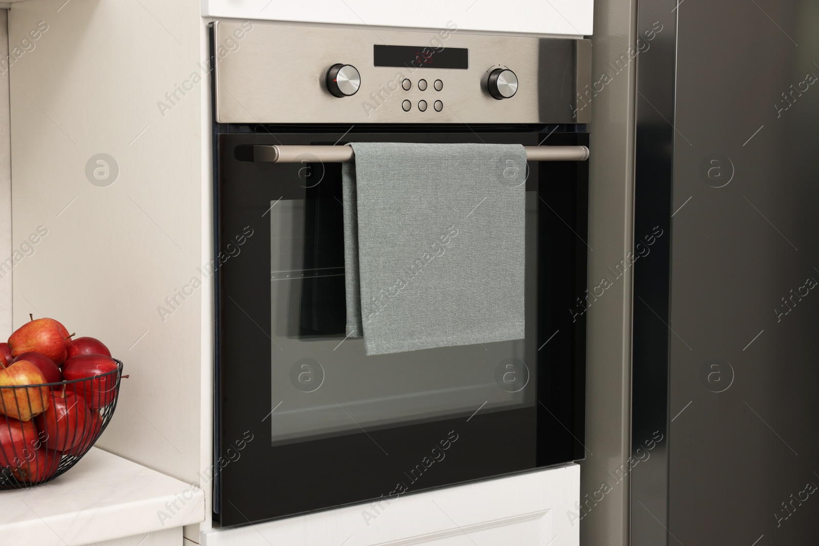 Photo of Electric oven with towel in kitchen. Cooking appliance